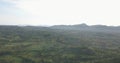 Aerial drone footage of a tropical landscape, with forest and mountains Kumbira forest reserve, small village and huge geologic