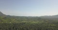 Aerial drone footage of a tropical landscape, with forest and mountains Kumbira forest reserve, small village and huge geologic