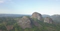 Aerial drone footage of a tropical landscape, with forest and mountains Kumbira forest reserve, small village and huge geologic