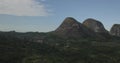 Aerial drone footage of a tropical landscape, with forest and mountains Kumbira forest reserve, small village and huge geologic