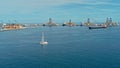 aerial drone image of the harbor with cargo container oil tanker ships and a sailboat at the approach area