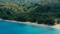 Aerial drone image of a south pacific village on a remote island with sandy beach shore and lush tropical rainforest jungle with Royalty Free Stock Photo