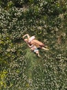 Aerial drone: Mother having quality funny playing time with her baby girls at a park blowing dandelion - Young blonde Royalty Free Stock Photo