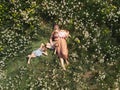 Aerial drone: Mother having quality funny playing time with her baby girls at a park blowing dandelion - Young blonde Royalty Free Stock Photo