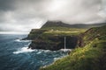 Aerial drone panorama of Gasadalur village and Mulafossur its iconic waterfall, Vagar, Faroe Islands, Denmark. Rough see