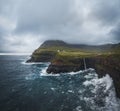 Aerial drone panorama of Gasadalur village and Mulafossur its iconic waterfall, Vagar, Faroe Islands, Denmark. Rough see