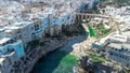 Aerial drone panorama of polignano a mare, picturesque puglian coastal city with beach carved into stone walls i to s Royalty Free Stock Photo