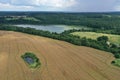 Aerial drone perspective view on beautiful rural landscape with yellow wheat field, green corn fields, green meadows, forest, lake