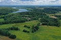 Aerial drone perspective view on beautiful rural landscape with yellow wheat field, green corn fields, green meadows, forest, lake