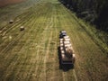 Aerial Drone Photo of Farmer Harvesting Hay Rolls in the Wheat Field with a Red Tractor - Sunny Summer Day, Vintage Look Edit Royalty Free Stock Photo
