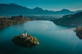 Aerial drone photo of lake Bled island with church on a cold hazy foggy early autumn morning. Visible scenery and fog around the Royalty Free Stock Photo