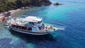 Aerial drone photo of pleasure yacht anchored in crystal clear bay and turquoise beach. uninhabited island in