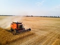 Aerial drone photo of red harvester working in wheat field on sunset. Combine harvesting machine driver cutting crop in Royalty Free Stock Photo