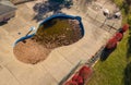 Aerial drone photo of an uncovered swimming pool filled with fallen autumn leaves