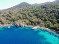 Aerial drone photo of yacht anchored in crystal clear bay and turquoise beach. uninhabited island in mediterranean sea Royalty Free Stock Photo