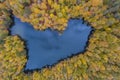 Aerial Drone Photograph of a Heart Shaped Lake Surrounded with Beautiful Autumn Colors of the Forest
