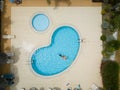 Aerial drone picture about a beautiful, blue ,outdoor swimming pool with playing children. Royalty Free Stock Photo