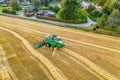 Aerial drone shot of combine harvester, harvesting at small wheat field, close to traditional Swedish on the countryside, Sweden. Royalty Free Stock Photo