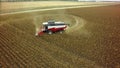 Aerial drone shot of a combine harvester working in a field. Tractors and farm machines harvesting corn in Autumn Royalty Free Stock Photo