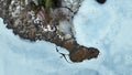 Aerial drone shot of frozen lake in winter with land part that looks like boot