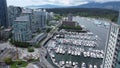 Aerial drone shot of the harbor with numerous parked boats near downtown Vancouver, Canada