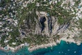 Aerial drone shot of mountain top villa with pool above big mountain hole cave in south Capri Island