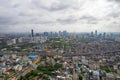 aerial drone shot over gurgaon showing monsoon clouds with light rays falling on ground crowded with homes houses, sohna highway