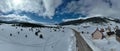 Aerial, drone shot over leafless trees, above a snowy mountain and beautiful snowy mountain peaks. Winter wilderness, on Royalty Free Stock Photo