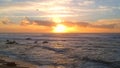 Aerial drone shot of silhouetted birds flying in front of setting sun at sunset over beach in Portugal