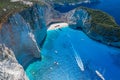 Aerial drone shot of Zakynthos Navagio beach with tourists with cruise ship in blue Ionnian sea