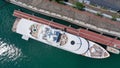 Aerial drone top down photo of luxury exotic yacht nose with wooden deck anchored in paradise turquoise bay. Luxury