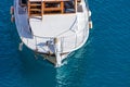 Aerial drone top down photo of luxury yacht nose with wooden deck anchored in paradise exotic turquoise bay