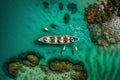 Aerial drone top down photo of sport canoe operated by team of young men in emerald calm sea waters Royalty Free Stock Photo