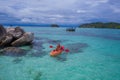 Aerial top view of man kayaking in crystal clear lagoon sea water near Koh Kra island in Thailand