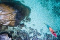 Aerial top view of man kayaking in crystal clear lagoon sea water near Koh Kra island in Thailand