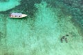 Aerial drone top view of people snorkeling over coral reef with clear blue turquoise ocean water. Pulau Tinggi, Malaysia