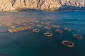 Aerial drone top view of sea fish farm cages and fishing nets, farming dorado, sea bream and sea bass, feeding the fish a forage,