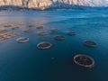 Aerial drone top view of sea fish farm cages and fishing nets, farming dorado, sea bream and sea bass, feeding the fish a forage,