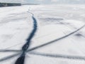 Aerial drone top view of snow covered frozen lake or river surface with big cracked ice diagonal lines. Natural winter Royalty Free Stock Photo