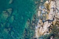 Aerial top view of turquoise sea surface with stones and rocks in water Royalty Free Stock Photo
