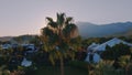 Aerial drone video footage. View of the hotel at sunset. Palms. Mountain landscape on the background.