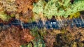 Aerial drone view of autumn landscape and road from above, yellow, green and red golden autumn trees and country road Royalty Free Stock Photo