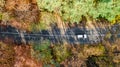 Aerial drone view of autumn landscape and road from above, yellow, green and red golden autumn trees and country road for cars Royalty Free Stock Photo