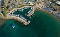 Aerial drone view of beach with people swimming and fishing boats moored at the harbor. Protaras Paralimni Cyprus Royalty Free Stock Photo