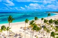 Aerial drone view of beautiful atlantic tropical beach with palms, straw umbrellas and boats. Bavaro, Punta Cana, Dominican