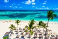 Aerial drone view of beautiful atlantic tropical beach with palms, straw umbrellas and boats. Bavaro, Punta Cana, Dominican