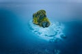 Aerial drone view of a beautiful secluded cliff island surrounded by azure turquoise blue ocean water. Bacuit