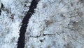 Aerial drone view of a black creek in the snowy winter forest. Royalty Free Stock Photo