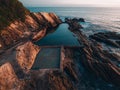 Aerial drone view of Blue Pool in Bermagui during sunrise sunset with blue sky and reflection. New South Wales