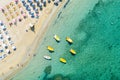 Aerial drone view of boats and beach with straw umbrellas with turquoise water. Ionian sea, Kefalonia Island, Greece